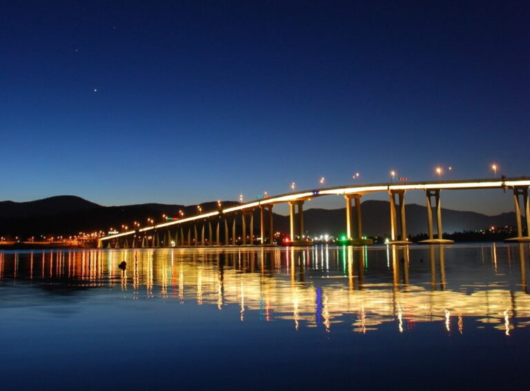 Tasman Bridge at dusk lit up with a reflection on the Derwent river.
