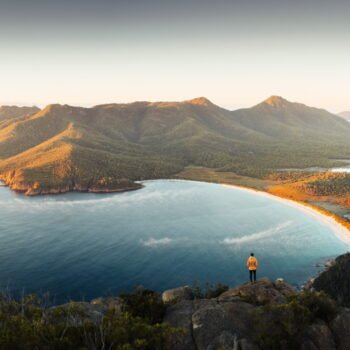 Wineglass Bay shot from a lookout on the western side, showing the bay and peninsula at sunset