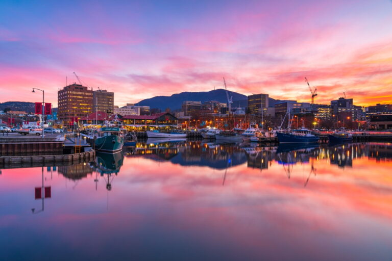 Hobart waterfront at sunset, city marina and city skyline under hues of purple and orange