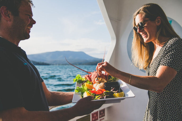 Luxury Bespoke Private tour with a couple holding a lobster meal on a boat