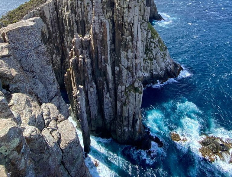 Totem pole cliffs with large vertical stones protruding from the churning sea